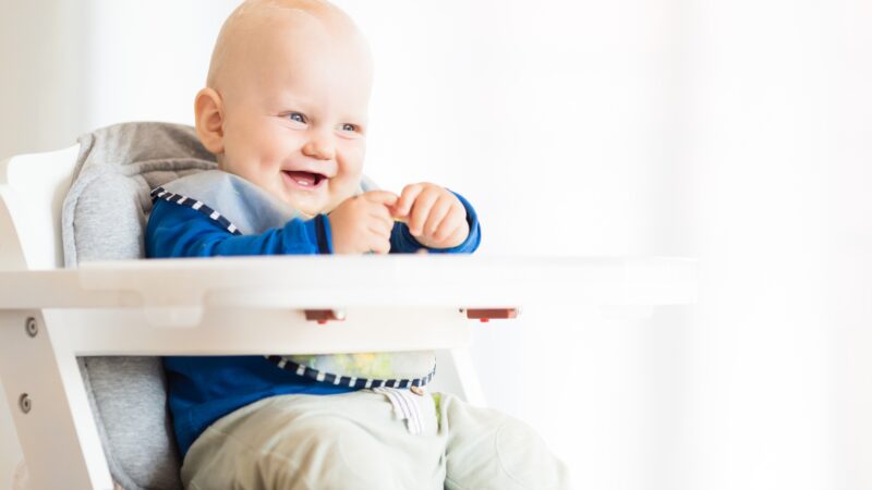 Baby boy eating with BLW method, baby led weaning