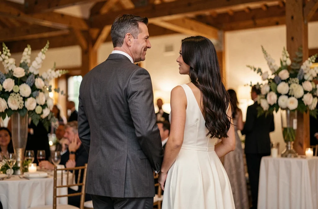Couple célèbre lors d'une réception de mariage élégante, homme en costume gris et femme en robe ivoire